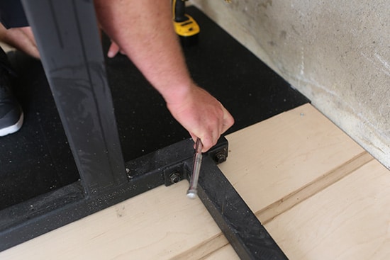 Man Tightening the Bolt of the Rack to the Platform.