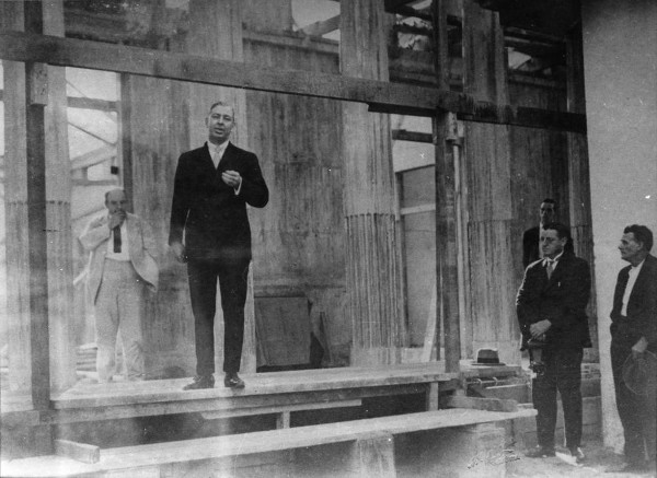 Vintage man businessman giving speech in hall.