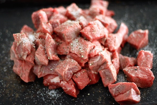 Raw cubed beef with salt and pepper.