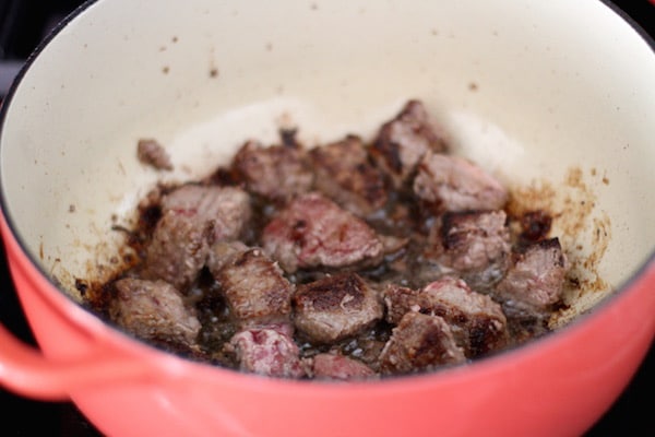 Beef cubes cooking searing in dutch oven pot homemade beef stroganoff.