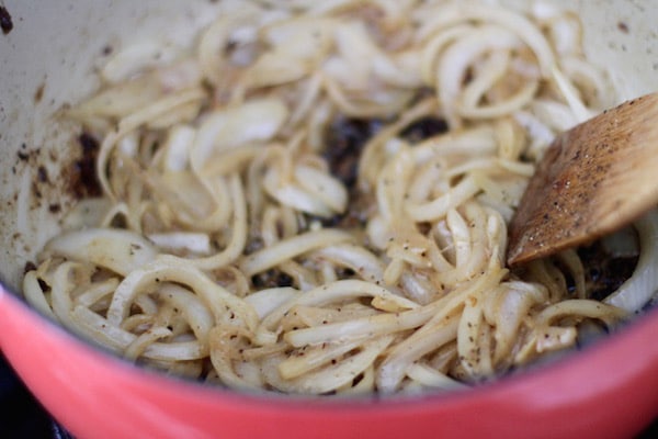 Homemade beef stroganoff stirring in onions.