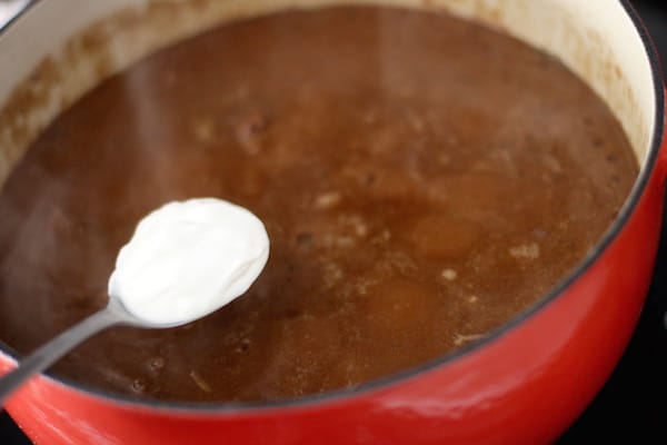 Homemade beef stroganoff stirring in sour cream.
