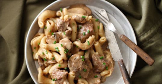 A bowl of Beef Stroganoff pasta with meat and mushrooms.