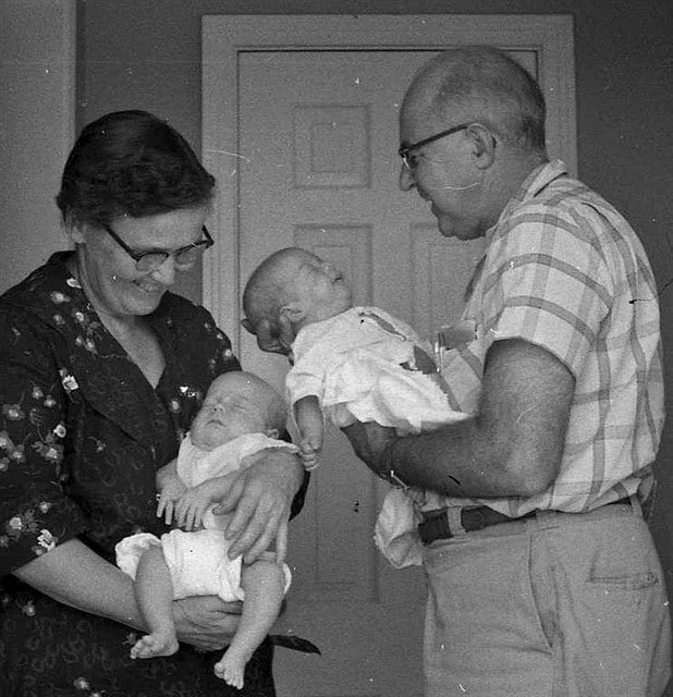 A black and white photo of a grandmother holding a baby.