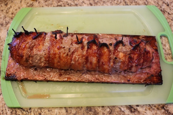 Prepared grilled bacon wrapped meatloaf in a tray. 