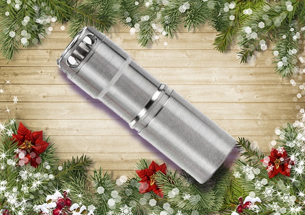 Titanium EDC flashlight placed on a decorated board.