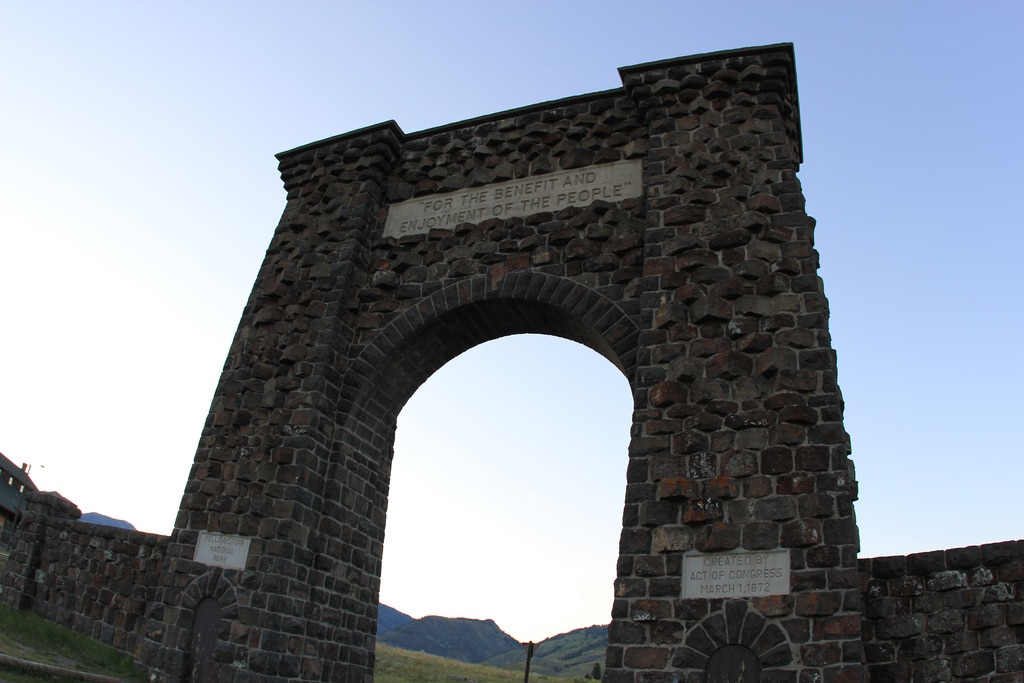 A large stone arch with a sign.