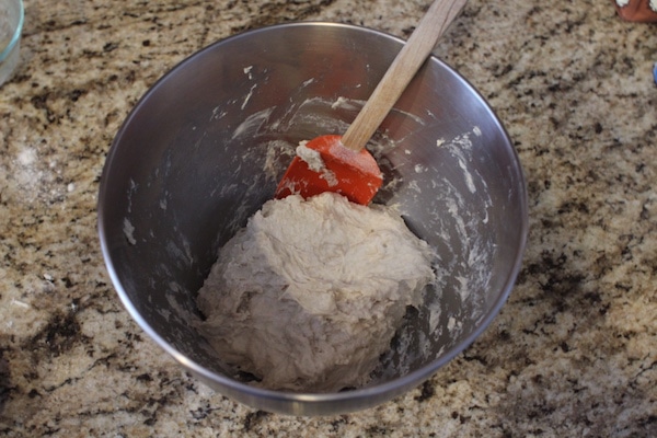 Mixing of dough with spatula in a steel bowl.
