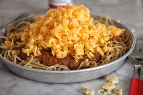 Homemade cincinatti chili in a bowl with shredded cheese.