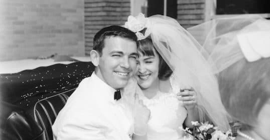 A black and white photo of a bride and groom in a car captures the essence of marriage.