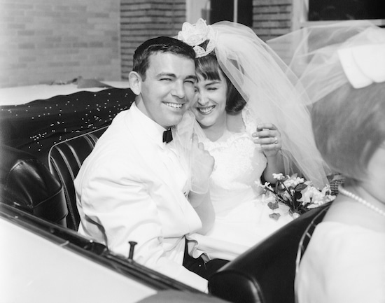 A black and white photo of a bride and groom in a car captures the essence of marriage.