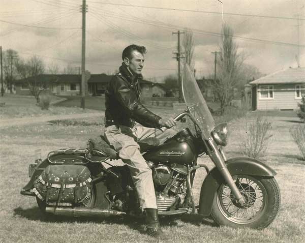 Vintage young man on motorcycle wearing leather jacket.