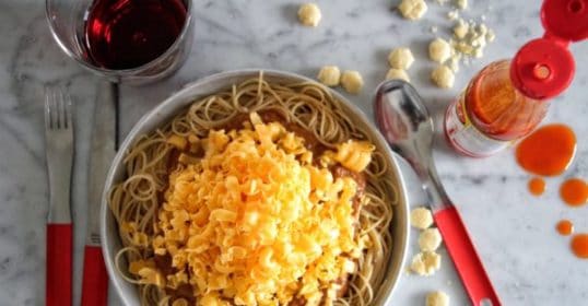 A bowl of spaghetti with cheese and sauce can be easily made using this Cincinnati-Style Chili recipe.