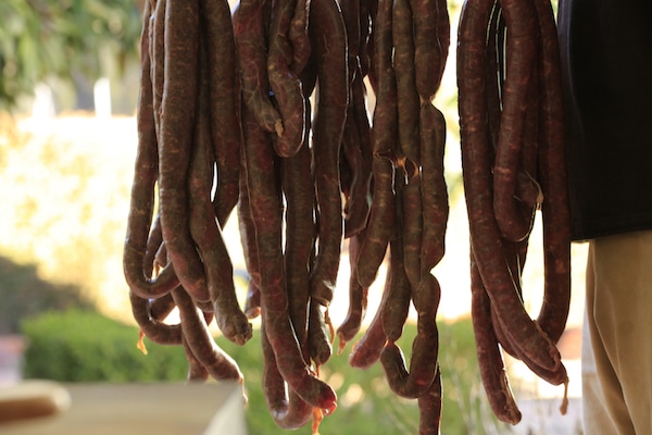 Homemade sausage hanging drying in casings.