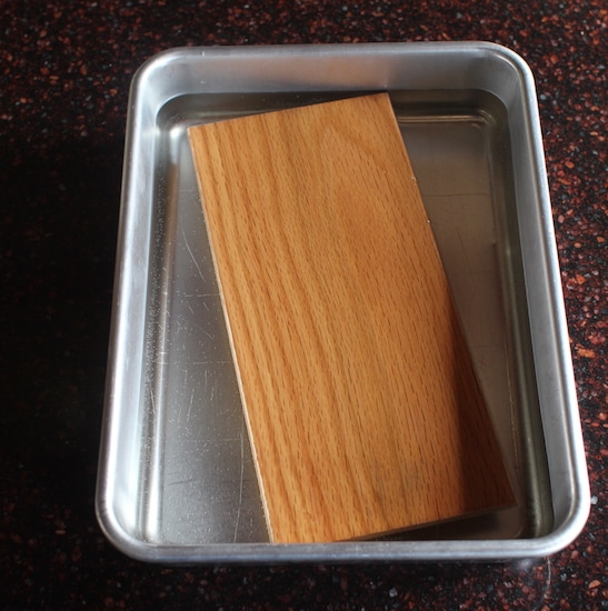 Wood grilling plank soaking in water.