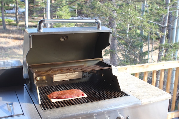 Flat iron steak on wood grilling plank.