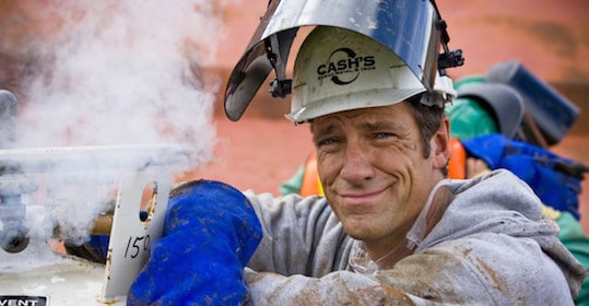 A man, wearing a hard hat and helmet, with steam rising from it.