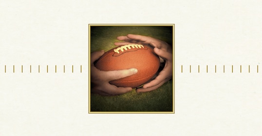 The book cover features a hand holding a football, symbolizing manhood.