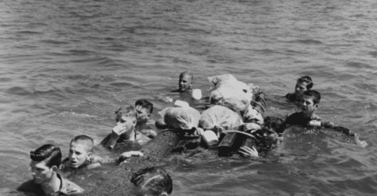 A group of people swimming in the river with a crocodile.