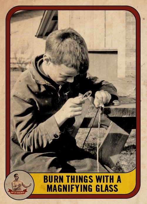 Vintage boy burning a stick with a magnifying glass.