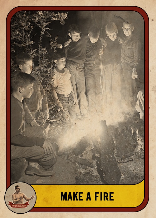 Vintage group of boys standing around a campfire.