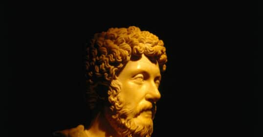 A bust of Marcus Aurelius in a dark room, evoking reflections.