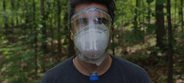 A man wearing an improvised gas mask in the woods.