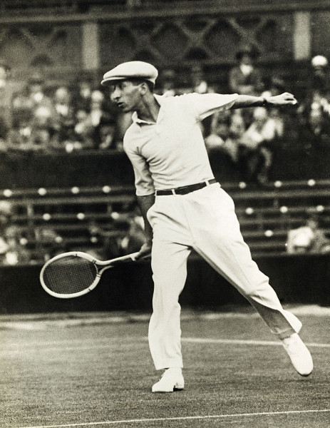 Vintage rene lacoste playing tennis in front of crowd.