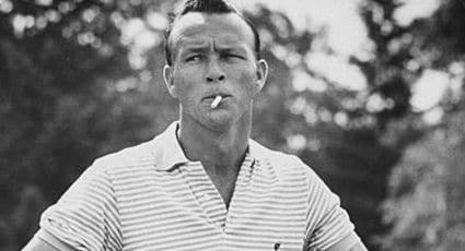 A stylish man smoking a cigarette in a black and white photo.