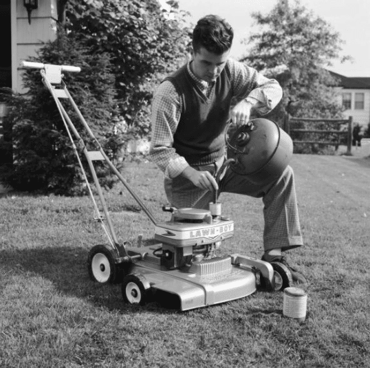 Vintage man pouring gasoline into lawn mower.