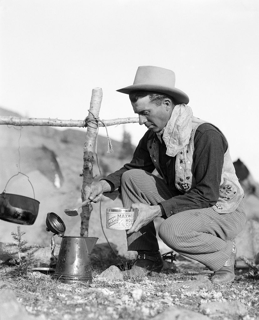 Vintage cowboy making coffee over a fire.