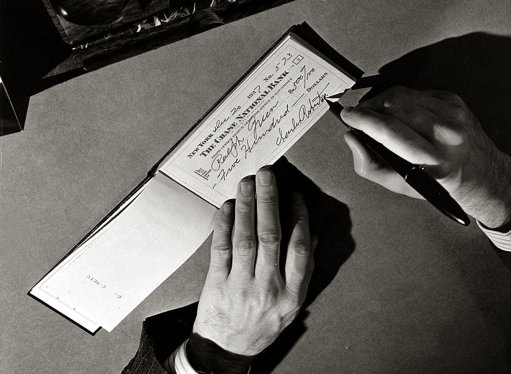 Vintage man to writing a check. 