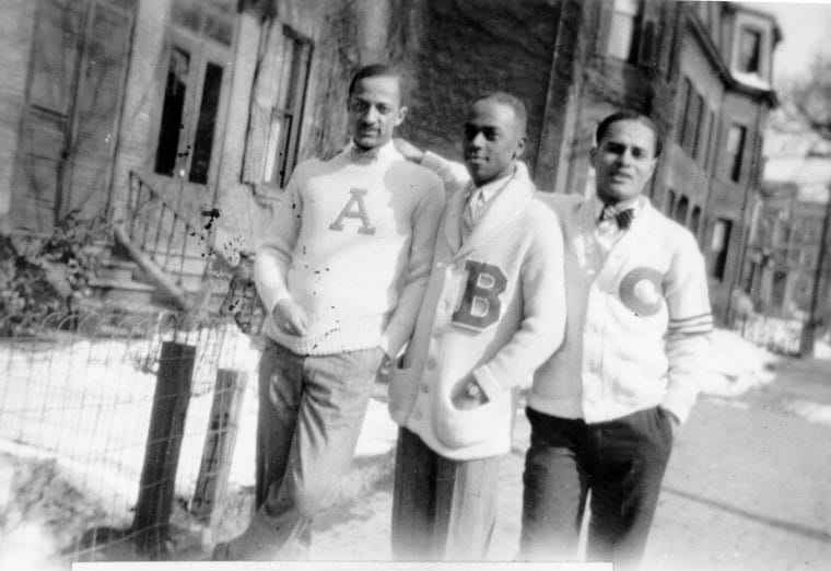 Vintage men standing on sidewalk with letter jacket cardigans.