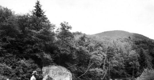 Learn how to fly fish in a river by studying this old black and white photo of a man fishing.