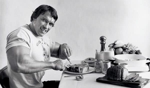 Vintage arnold schwarzenegger eating steak smiling. 