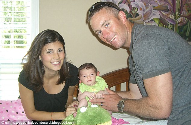 A soldier and his wife are posing for a picture with their baby.