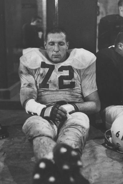 Vintage football player sulking in locker room.