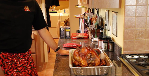 Woman preparing turkey in kitchen.