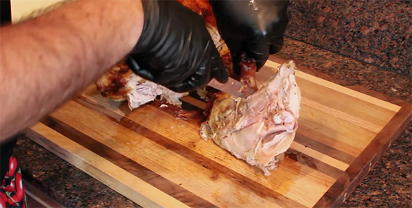 Separating the leg from the thigh of turkey.