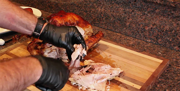 Cutting turkey's thigh meat with knife.