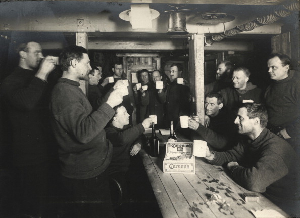 Vintage group of men giving a toast in a meeting hall.