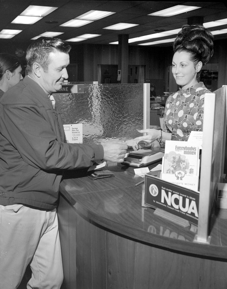 Vintage man cashing check at a bank.