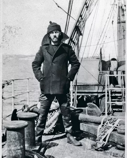 Vintage seaman on a boat deck wearing a pea coat.