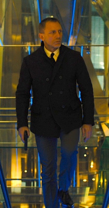 Daniel craig james bond walking with pistol wearing pea coat.