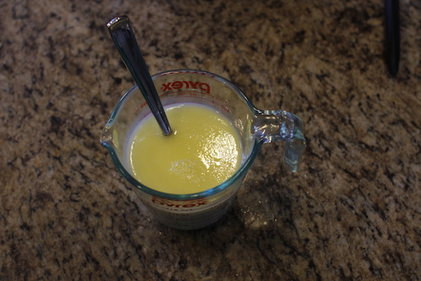 Milk, water, butter, and sugar added to a large measuring cup.