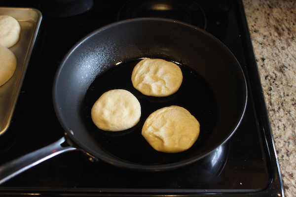 English muffins being cooked on skillet.