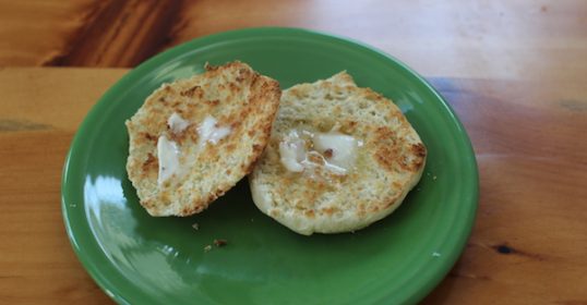 A green plate on a wooden table at home.