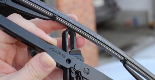A hand holding a black blade.