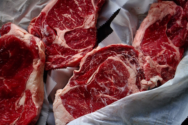 Frozen beef steaks are being displayed.