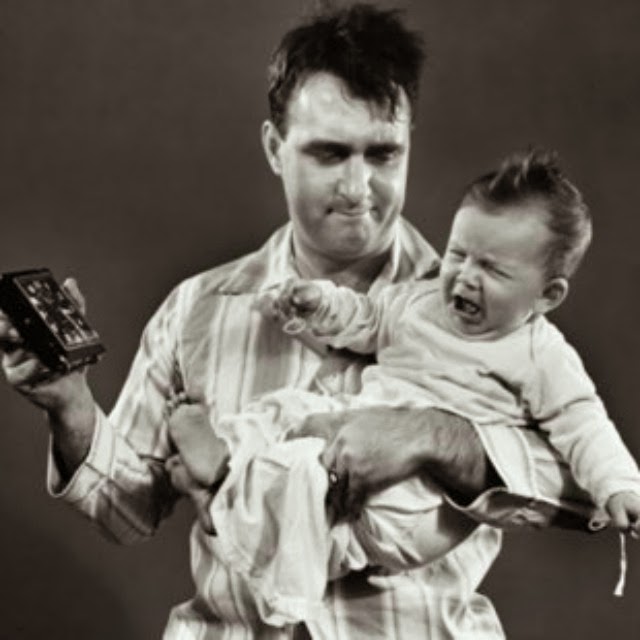 A black and white photo of a calm man holding a baby.